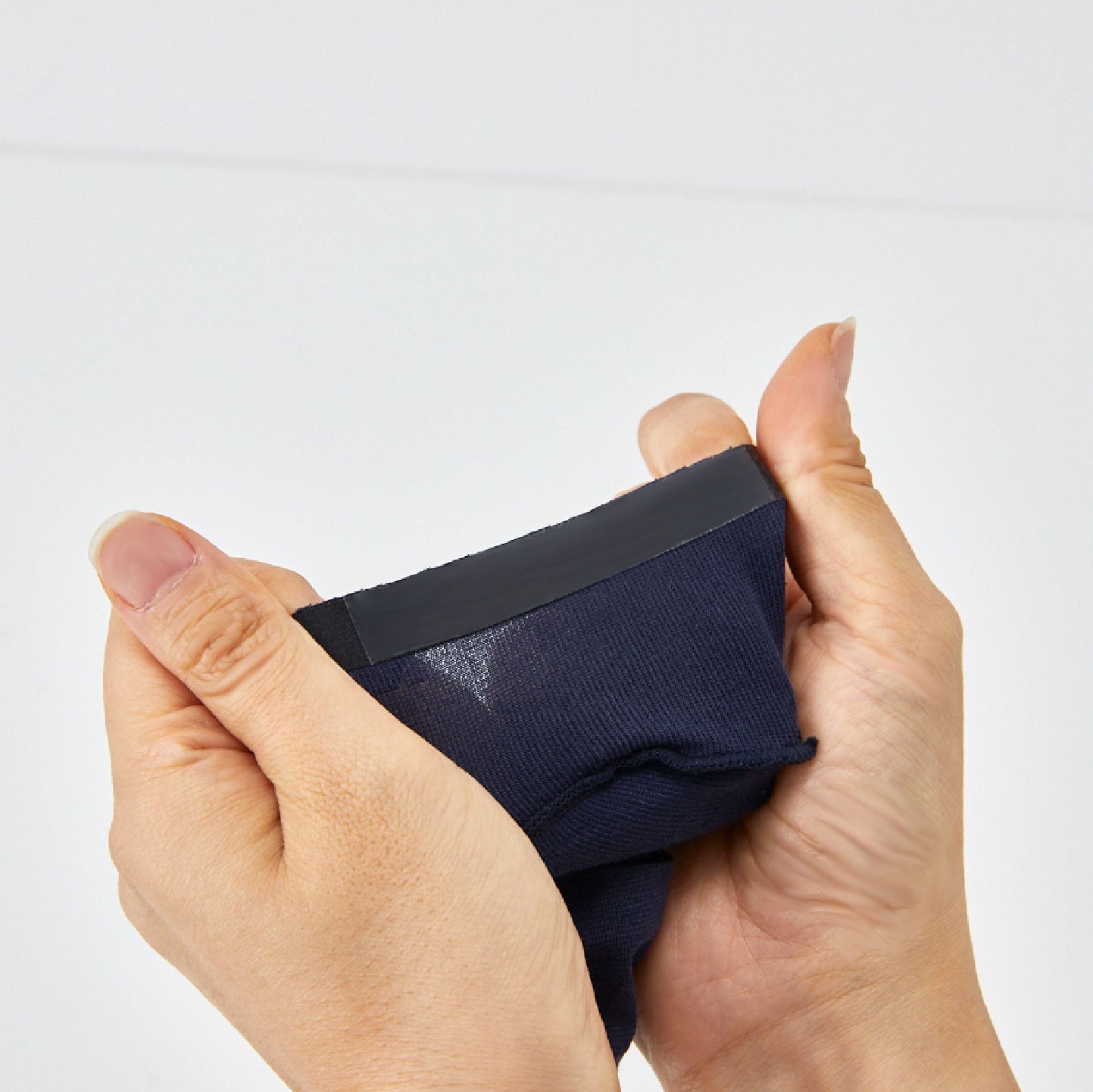 Inside out sock heel stretched between hands, highlighting the slip prevention heel of ONDO socks