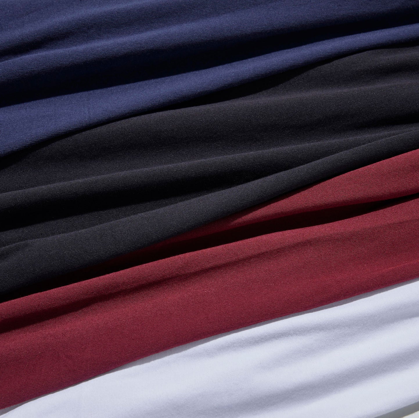 Closeup of ONDO sock materials in blue, black, maroon, and white, depicting how the socks wick sweat away from the skin