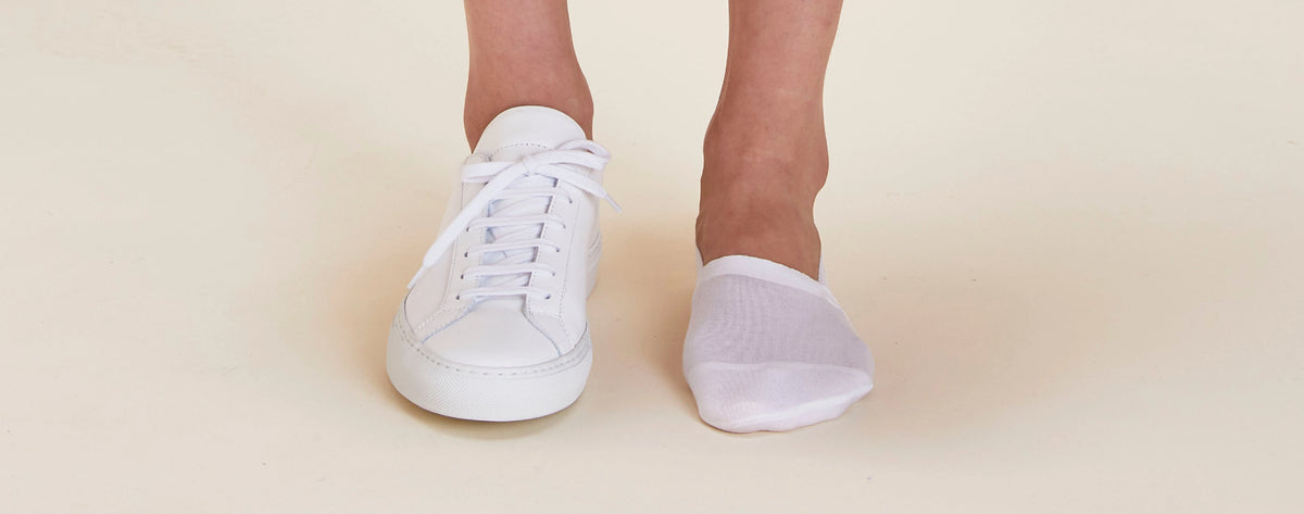 The Organic No Show Socks in Arctic White on foot paired with white sneakers