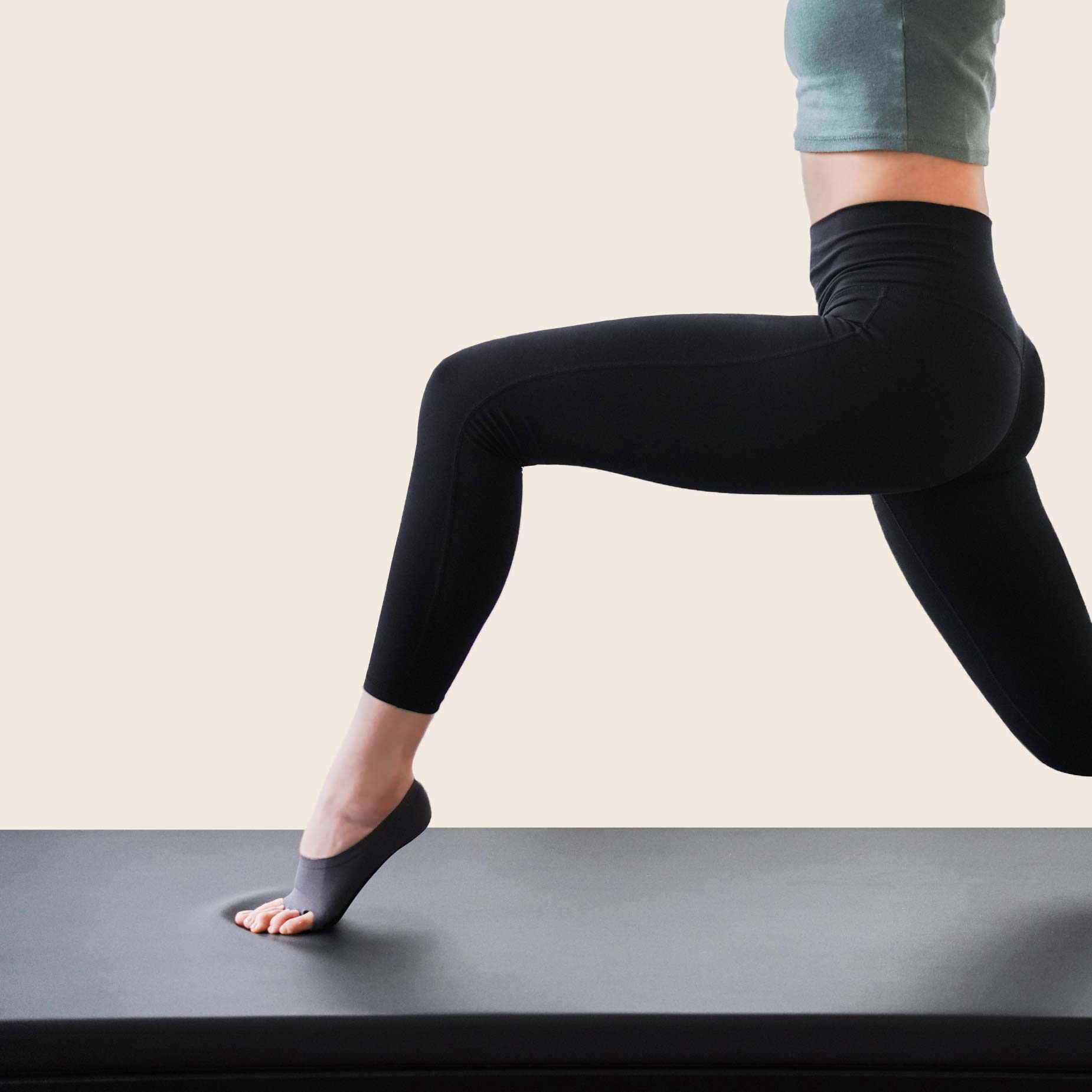 Woman on yoga mat wearing ONDO Yoga/Pilates socks in Plum Purple, showing how the sock toe holes prevent sliding