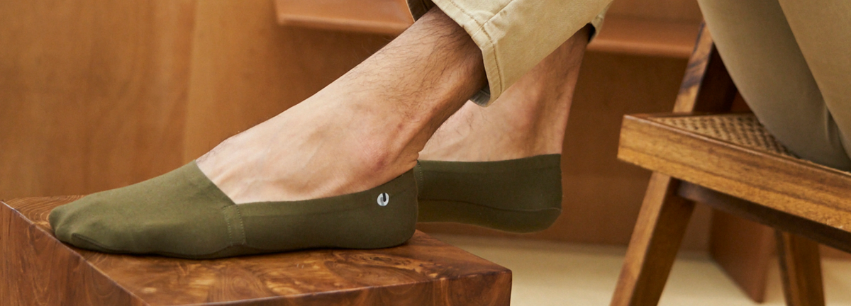 The Organic Cotton No Show Socks in Olive Green on foot